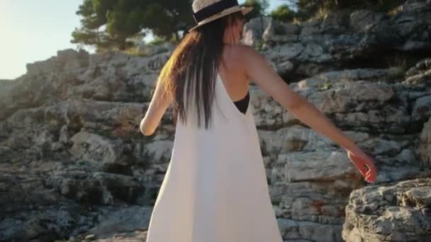 Joyeux jeune brunette dansant parmi les rochers — Video