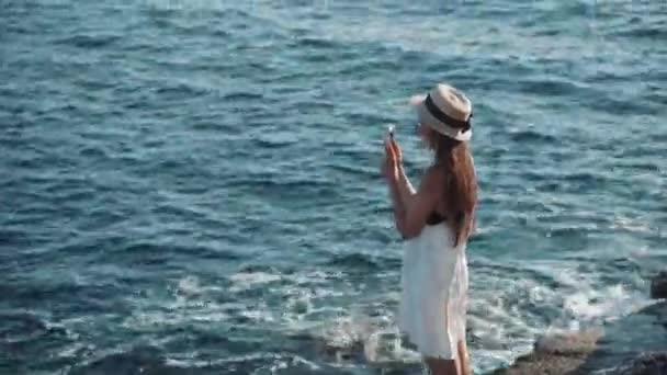 Девушка делает летние фотографии моря — стоковое видео