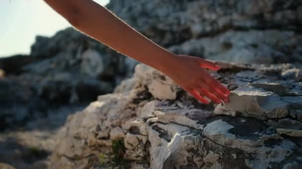 Girl walking on the coast and touching rocks — 비디오