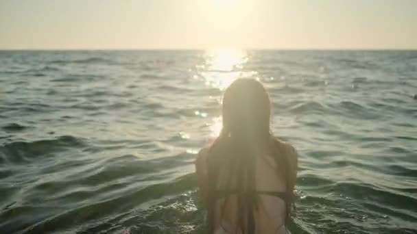 Femme nageant dans la mer au coucher du soleil — Video