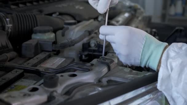 Trabajador está desatornillando perno dentro del coche por destornillador — Vídeos de Stock