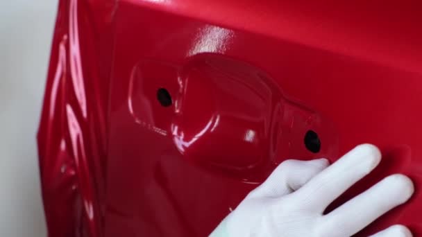 Werknemer is gladstrijken vinyl tape op auto-lichaam en blazen door ventilator in de garage — Stockvideo