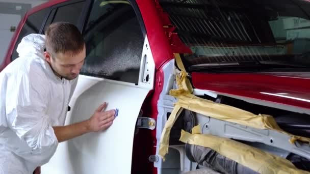 Trabajador hombre está puliendo tinte en la carrocería del coche a mano en el servicio de coche — Vídeos de Stock