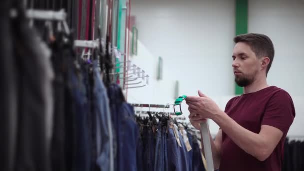 Hombre comprando un cinturón en tienda de ropa — Vídeos de Stock