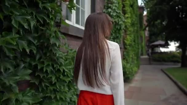 Chica caminando al aire libre y sonriendo a la cámara — Vídeos de Stock