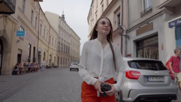 Flicka turist promenader på gatan i Krakow och ta bilder, Polen — Stockvideo