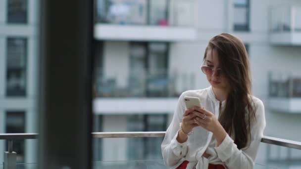 Ar respirando na varanda com smartphone nas mãos — Vídeo de Stock