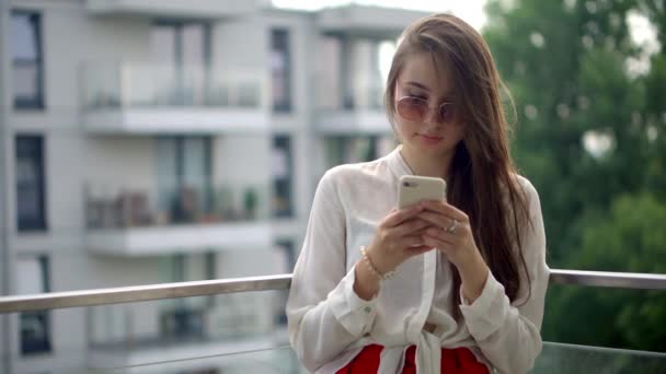 Girl with cell outside at the balcony — Stock Video