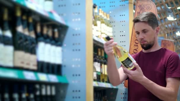 Клиент выбирает бутылку белого вина — стоковое видео