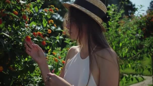 Дівчина пахне квітами в парку — стокове відео