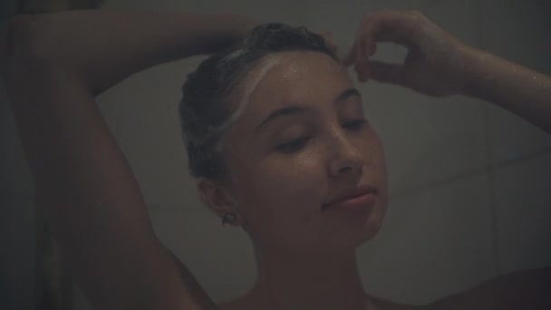 Junge Frau shampooniert Haare in der Dusche zu Hause — Stockvideo