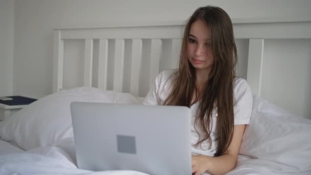 Mujer está trabajando con cuaderno sentado en la cama por la mañana — Vídeo de stock