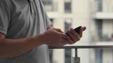 Adam akıllı telefon ekranında daktilo ediyor, kayıyor ve kayıyor.