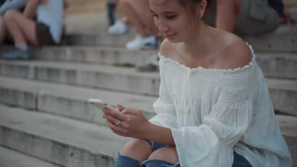 Κορίτσι που ξοδεύει ελεύθερο χρόνο σέρφινγκ στο smartphone — Αρχείο Βίντεο