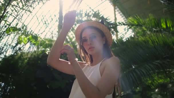 Mladá žena pózuje v tropickém sále botanické zahrady — Stock video