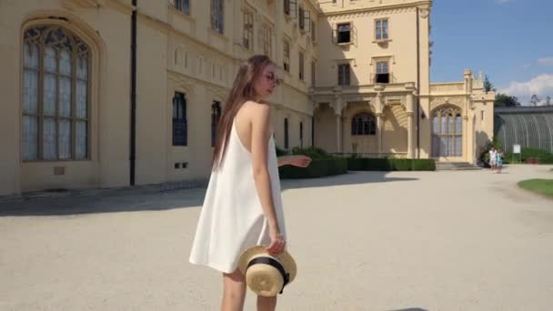 Kvinna ska till en byggnad av gamla neo gotiska palats — Stockvideo