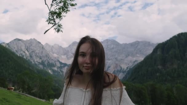 Portret młodej uśmiechniętej kobiety w tle Alp — Wideo stockowe