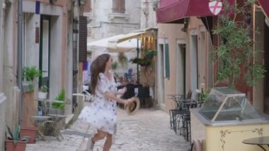 Kadın gezgin eski Avrupa şehrinin caddesinde koşuyor