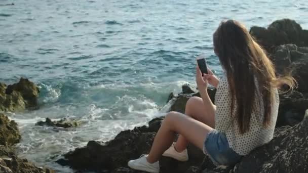 Ela adora passar o tempo sozinha à beira-mar. — Vídeo de Stock