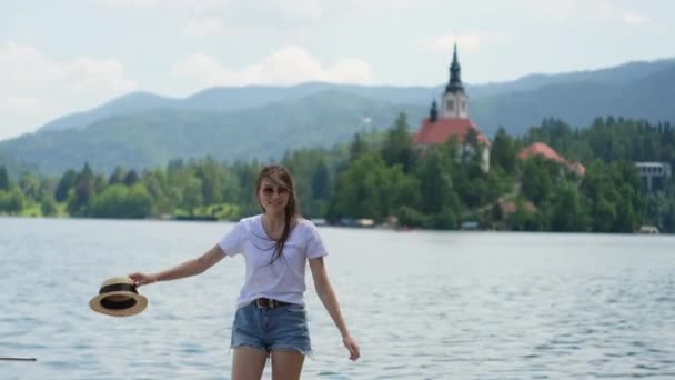 Mujer está caminando en la orilla del lago Bled en Eslovenia — Vídeos de Stock