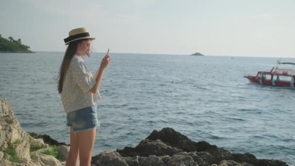 Turista mujer está utilizando el teléfono inteligente en la orilla del mar en Croacia — Vídeos de Stock