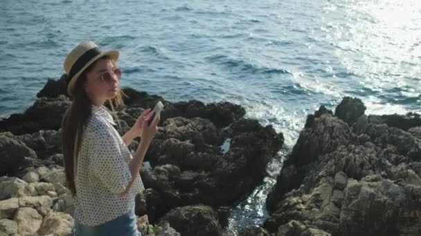 Mooi meisje op zee rotsen — Stockvideo