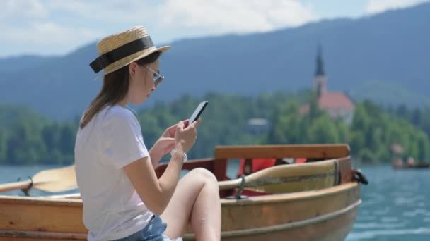 Kvinna tar foto av landskapet med ön på sjön Bled med smartphone — Stockvideo
