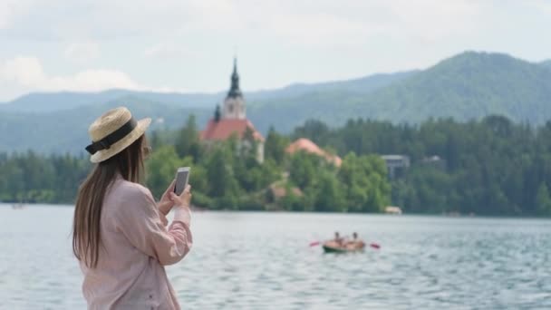 Tomando fotos de memoria del paisaje del lago Bled en Eslovenia — Vídeos de Stock