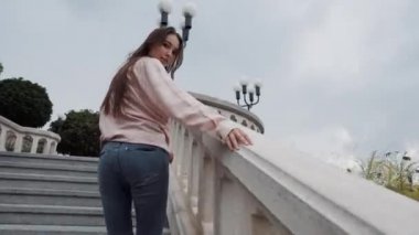 Dışarıda merdivenlerden çıkan uzun saçlı güzel kız.