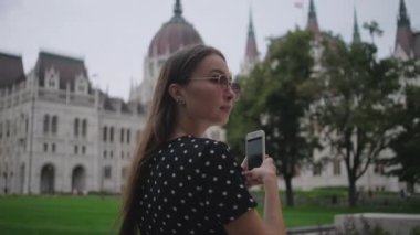 Kadın, Macar Parlamento Binası 'nın cep telefonuyla fotoğraf çekiyor