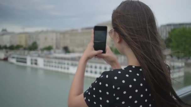 Girl making city photos from the bridge. Budapest, Hungary — 비디오