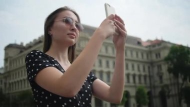 Kadın gezgin akıllı telefonla Macaristan 'ın simgelerinin fotoğrafını çekiyor.