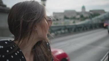 woman is resting on automobile bridge in city