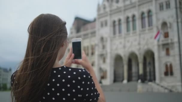 Chica tomando fotos móviles del edificio del Parlamento en Budapest, Hungría — Vídeo de stock
