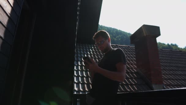 Людина з мобільним телефоном за межами будинку — стокове відео