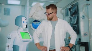 Bilim adamı laboratuvarda insansı robotu kucaklıyor.