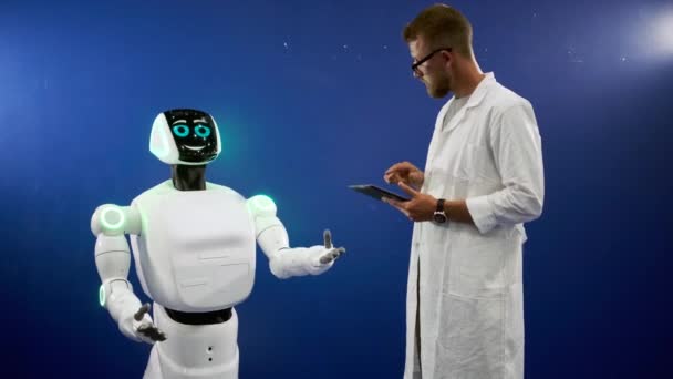 Автоматичний робот рухається і посміхається розробнику — стокове відео