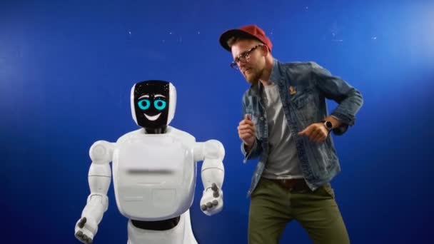 Hombre está bailando cerca de robot humanoide — Vídeo de stock