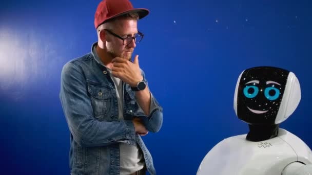 Humanoid robot is speaking to young man — Stock Video