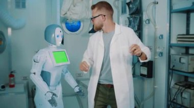 Çılgın bilim adamı ve insansı robot laboratuvarda dans ediyor.