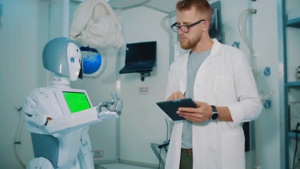 Uomo ingegnere sta ricercando movimenti robot umanoidi in laboratorio — Video Stock