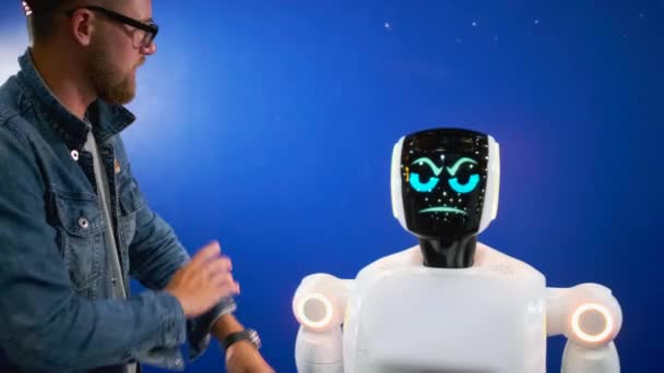 Man is talking with humanoid robot, it changes face expression — Stock Video