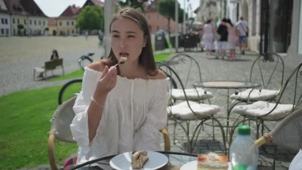 Girl enjoying dessert in outside cafe — Stockvideo