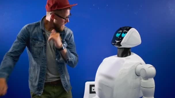 Homem engraçado está dançando na frente robô — Vídeo de Stock