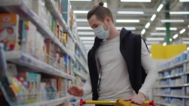 Maskeli adam süpermarketten bebek bakım ürünleri alıyor.