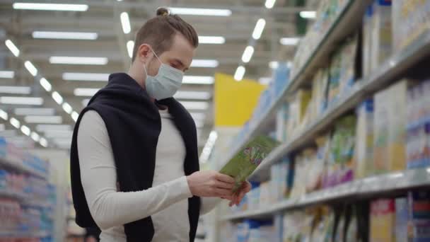 Hombre enmascarado en el supermercado durante la epidemia de coronavirus — Vídeos de Stock