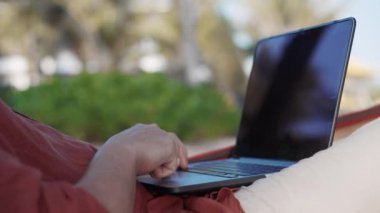 Adam dizüstü bilgisayarda touchpad 'i kaydırıyor.