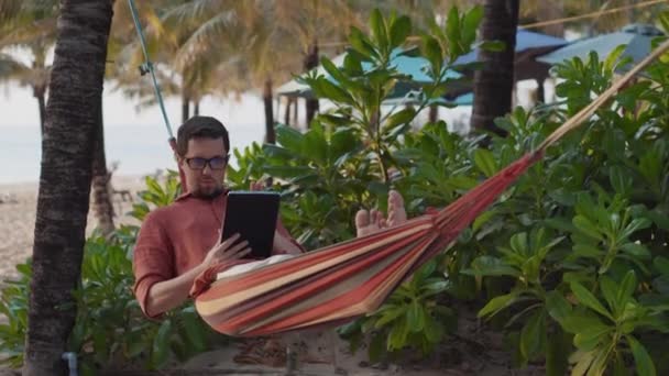 Relaxovat v houpací síti s tabletou — Stock video