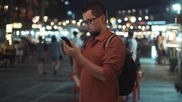 Turista hledá informace na internetu pomocí smartphonu na ulici — Stock video