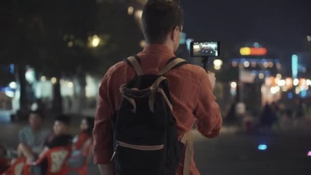 Homem fazendo vídeo móvel de caminhada na cidade noturna — Vídeo de Stock